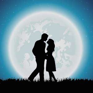 Silhouette of a couple kissing in front of a large glowing moon